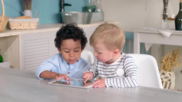 Little Multiethnic Boys Playing on Tablet at Home