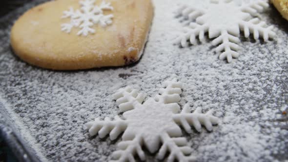 Heart shape cookies with snowflake and icing sugar on tray alt