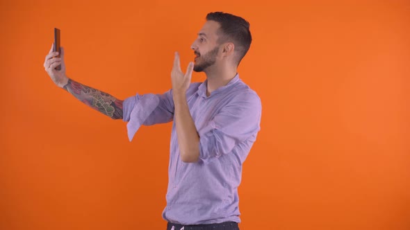 Young Man Video Calling Wife and Sending Kisses Concept. Working Abroad Connection Concept alt