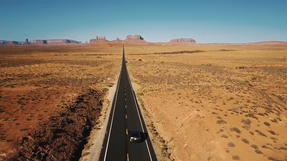 Amazing Aerial Shot of Silver Car Driving Along Amazing American Sandstone Desert Highway Road in