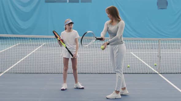 Little Girl Practicing Tennis Indoors alt