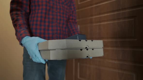 Delivery Man Holding Pizza Box and POS Wireless Terminal for Card Payment.