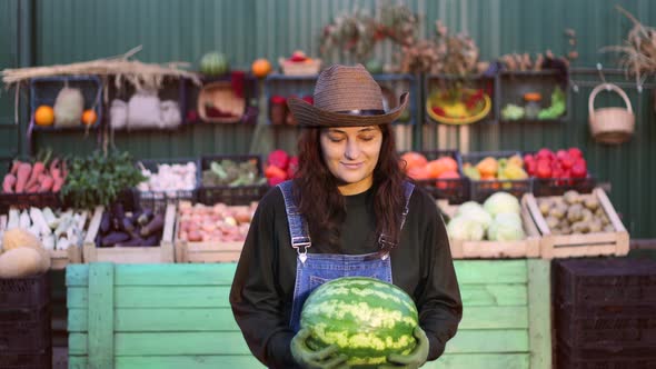 Woman Farmer (Seller) With Watermelon at the Farmer's Market. alt