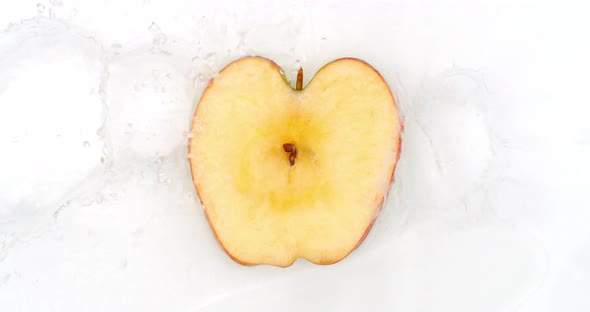 On a White Background, Sliced Apple Slices Are Sprinkled with Water. alt