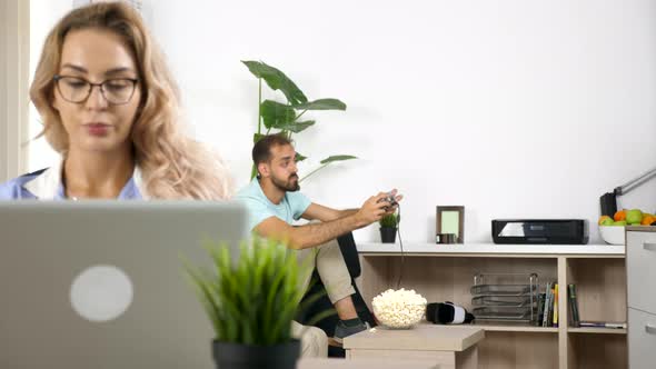 Noisy Boyfriend Plays Video Game While Freelancer Girlfriend Is Working at Home alt