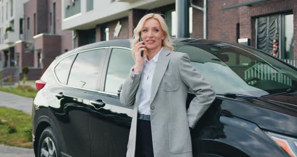 Business Confident Woman Talking on Phone Near Car Outdoors. Technology and People Concept alt