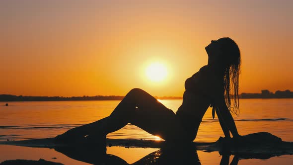 Silhouette Of Hot Woman In Swimsuit Lying And Posing On Evening Beach At Sunset Stock Footage