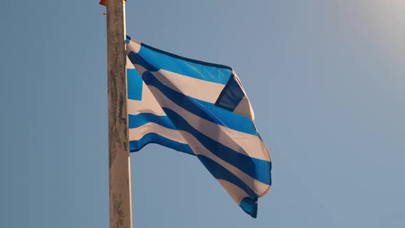 Greek Flag on the Pillar Waving on the Wind Over Sky Background alt