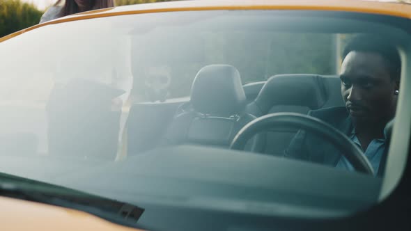 African Man in Suit Sitting Together with Caucasian Businesswoman on White Shirt alt