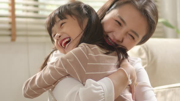 Happy little Asian Cute Girl hugging, embracing her mom