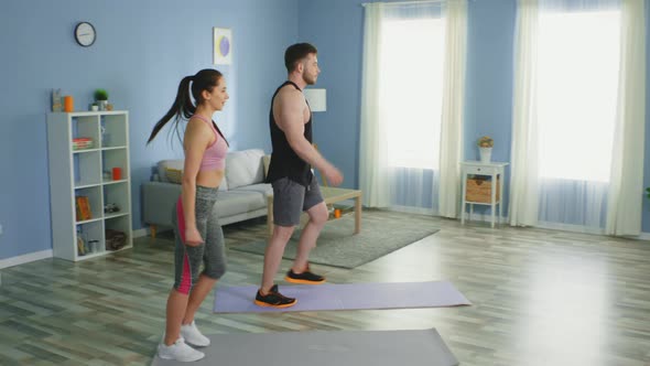 Woman and Man Are Doing Forward Lunges at Home