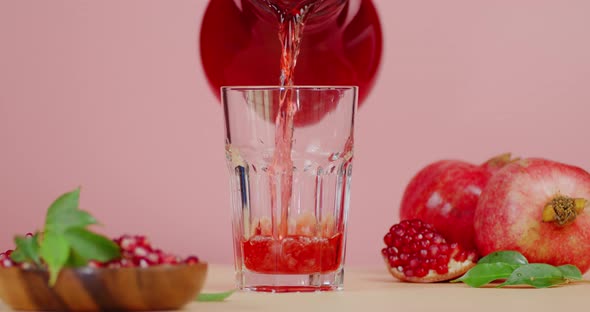 The Juice of Pomegranate Is Poured Into Glass From a Jug. 
