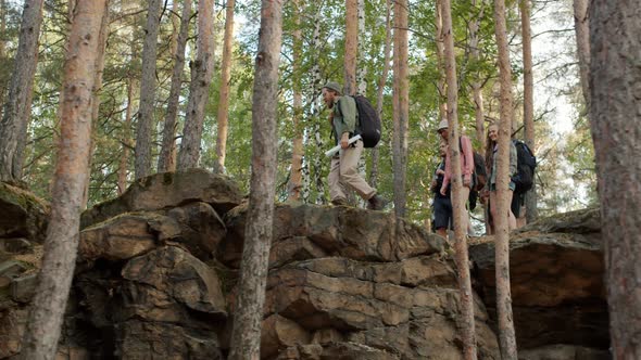 Slow Motion of Tourists Walking in Mountains Looking Around Through Binoculars Holding Map alt