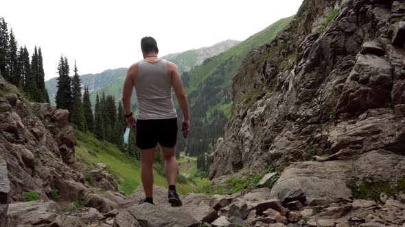 Guy in the Mountains Takes Off His Medical Mask. alt