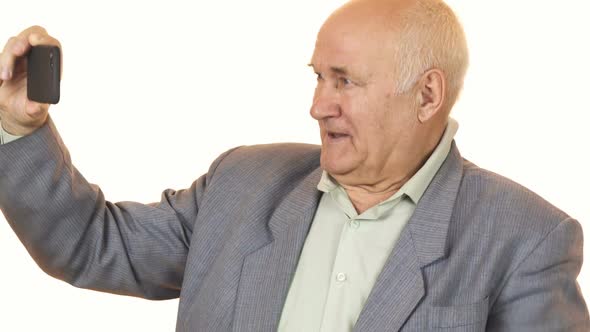 Joyful Senior Man Smiling Taking Selfies with a Smar Phone alt