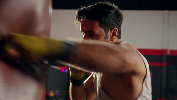 4K Caucasian man athlete do boxing exercise with punching bag at gym alt