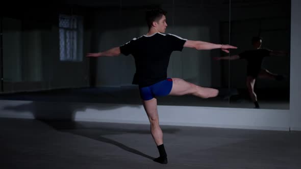 Wide Shot Talented Young Man Spinning Fast in Ballet Position Looking at Camera and Sitting Down alt