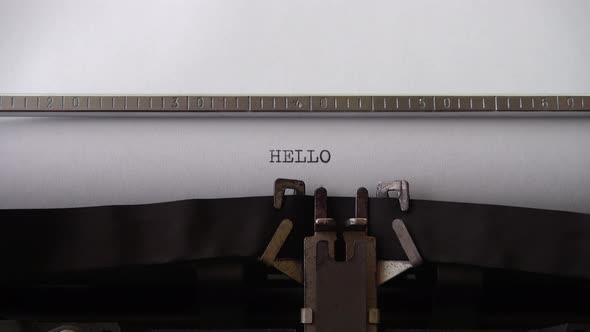 Typing word HELLO on retro typewriter. Close up. alt