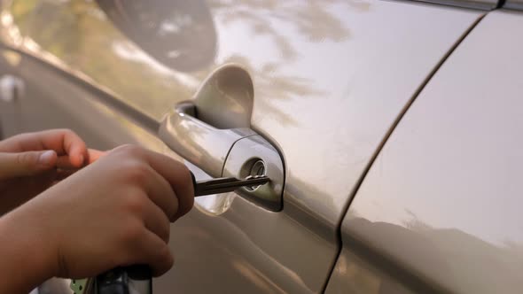Closeup of a Little Boy Opening a Car with a Key in Summer alt