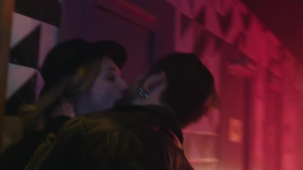 Young Couple Kisses in a Neon Light