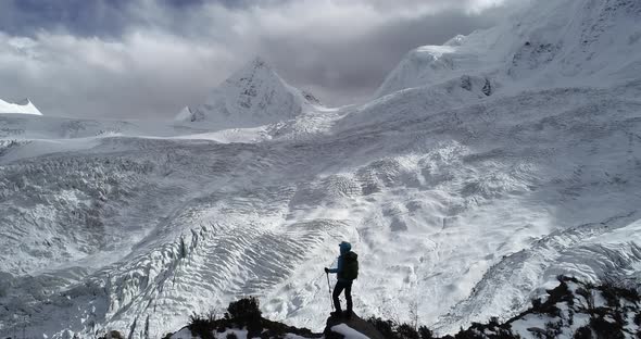 Woman backpacker hiking on winter mountain looking the glacier view alt