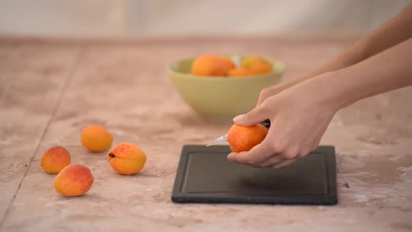 Woman in the Kitchen Cutting a Sweet and Fresh Apricots