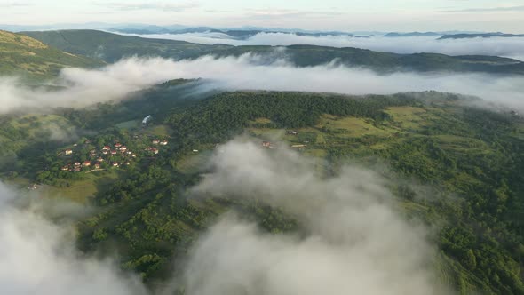 Aerial View Above Clouds and Green Mountains