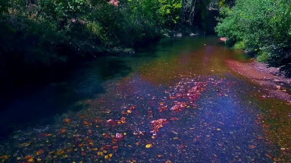 Drone shot flying backwards quickly over a small river alt
