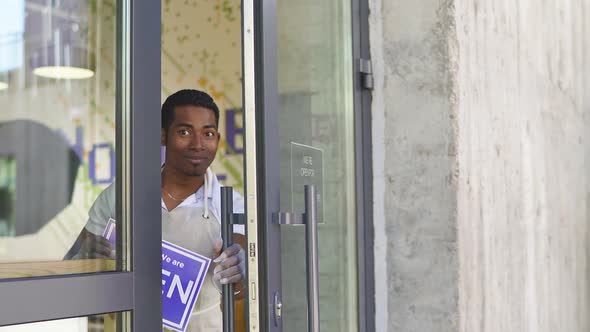 Handsome Smiling Man Hold Open Sign in Shop