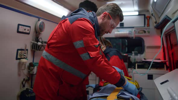 Emergency Doctors Performing First Aid Help to Man in Emergency Car alt