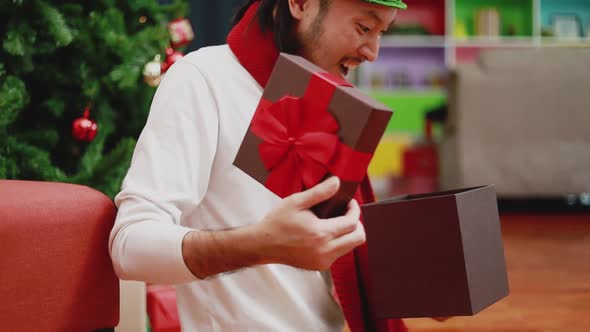 Young Asian men open the gift box in the living room at home.