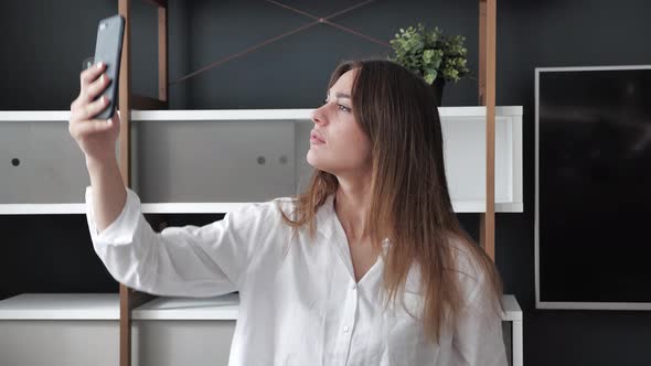 Cute Bussineswoman Tries to Connect to a Cellular Network Signal at Home in Modern Interior alt