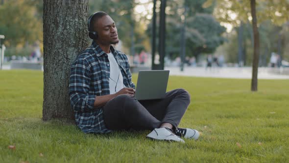 Happy Cheerful African American Business Man Guy Student Male Sitting on Green Grass Lawn with alt