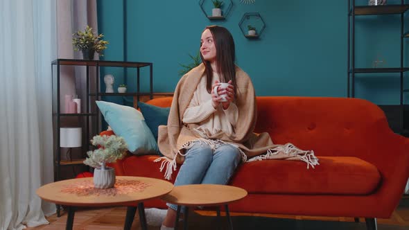 Portrait of Smiling Young Adult Woman in Warm White Sweater Drink Hot Beverage Mug Relaxing at Home alt