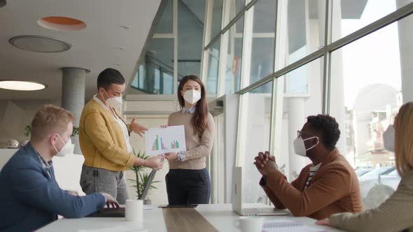 Group of young multiethnic business people working together with facial protection masks and prepari