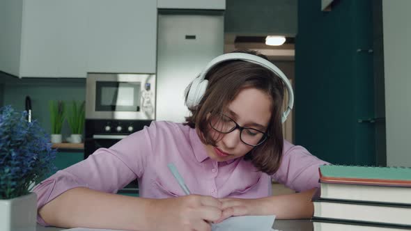 Happy Schoolgirl Pupil Wearing Headphones Raising Hand Distance Learning Online at Virtual Lesson alt