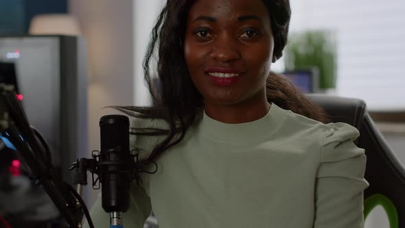 Black Woman Gamer Looking at Camera Smiling Sitting in Gaminig Room alt
