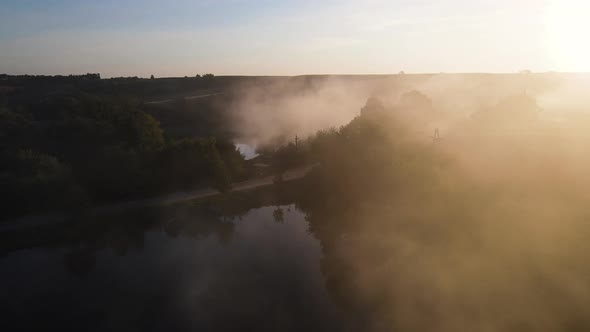 A Thick Fog Over a Small Lake at the Beautiful Sunrise