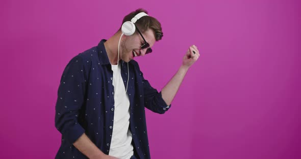 Man Dancing and Smiling Over Color Background While Listening to Music alt