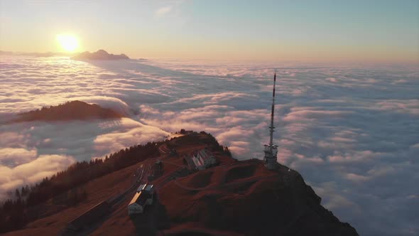 Sunset drone view to mountain top surrounded by a sea of clouds. Famous Rigi Mountain in Switzerland alt