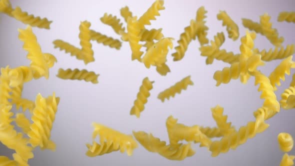Dry Pasta Fusilli is Bouncing and Rotating on a White Background alt