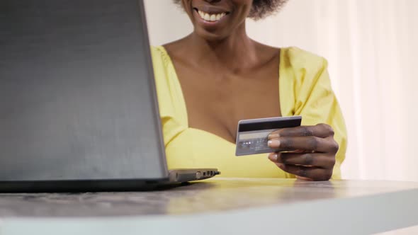 Beautiful African American Black Woman Uses a Bank Card to Shopping Online