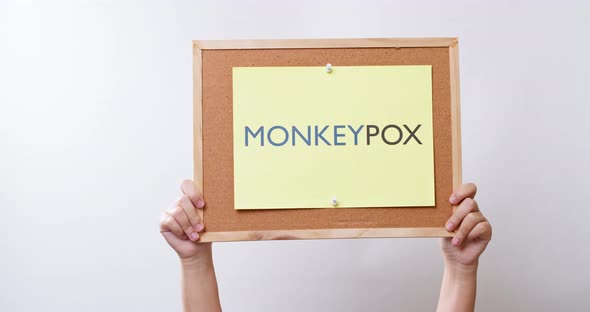 Woman hand shows a sheet of paper with the inscription monkeypox. A new virus in medicine. Infectiou alt