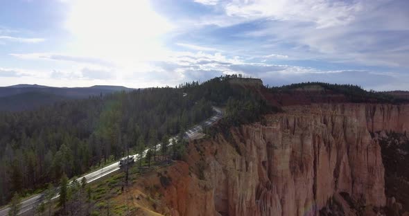 Drone shoots a video on a sunny day a white car on the highway in Zion National Park, Utah, USA alt