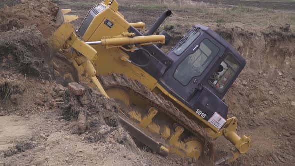 Bulldozer is Pushing Out Dirt Out of a Pit Using Its Bucket Heavy Machinery alt