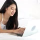 Beautiful asian young woman lying on bed using laptop at bedroom. - VideoHive Item for Sale