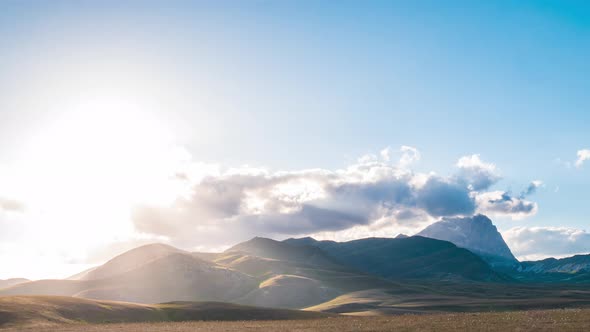 Time lapse: clouds moving in the sky, sunset view point over rocky mountains, highlands and pastures alt