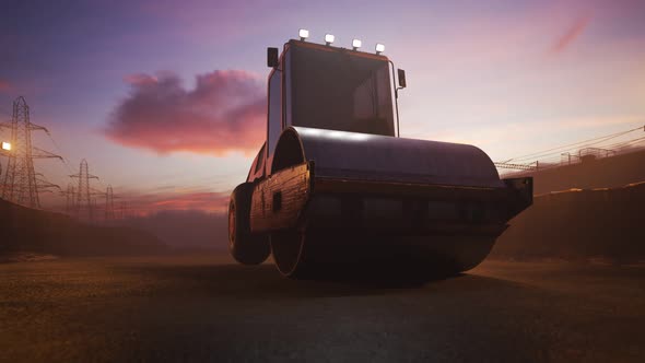 Sunset with yellow road roller paving the asphalt road in the construction site alt