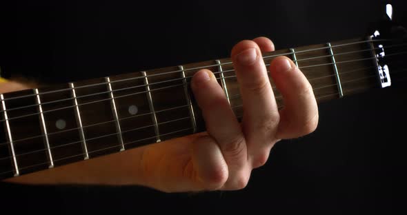 Closeup of the Musician's Fingers on the Guitar Neck