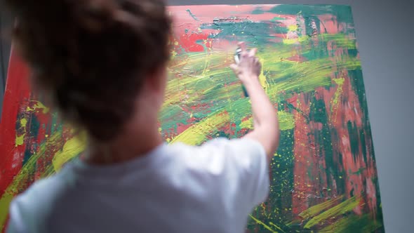 Back View Female Artist Draws with Spray Paint on a Large Canvas in a White Room a Talented Artist alt